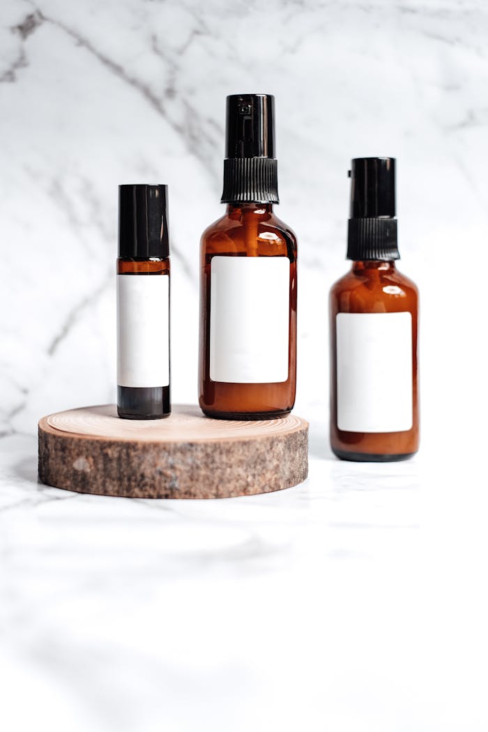 Brown glass bottles for skincare products on a marble background.