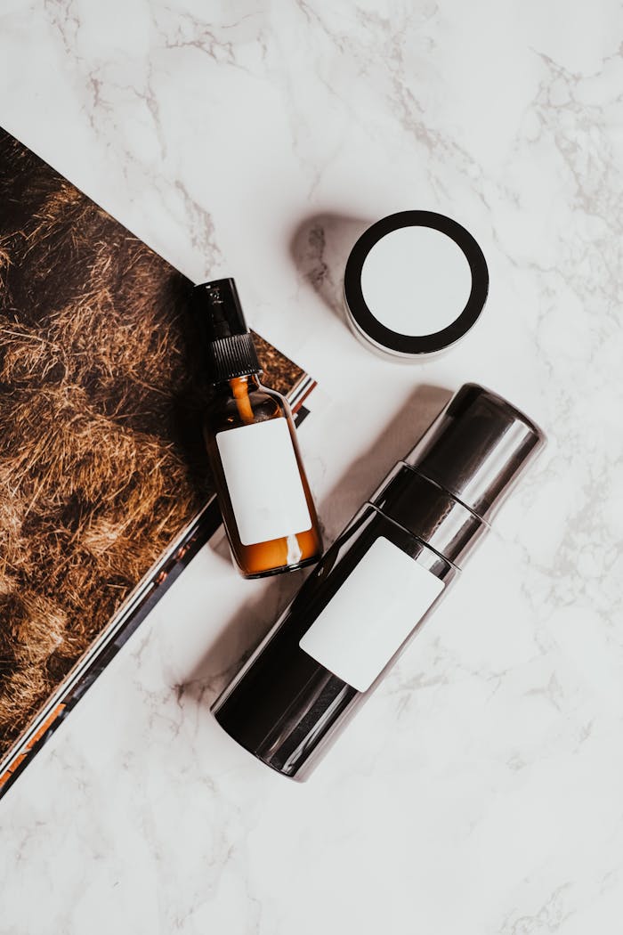 Stylish flatlay showcasing skincare bottles and a jar on a marble surface, perfect for beauty or lifestyle themes.